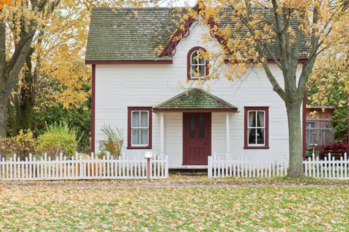 White country house with a wooden fence among trees