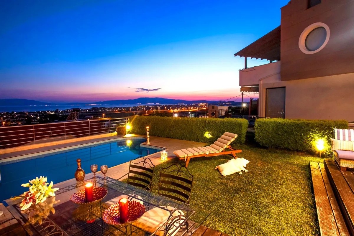 Terrace with a pool and a city view at dusk